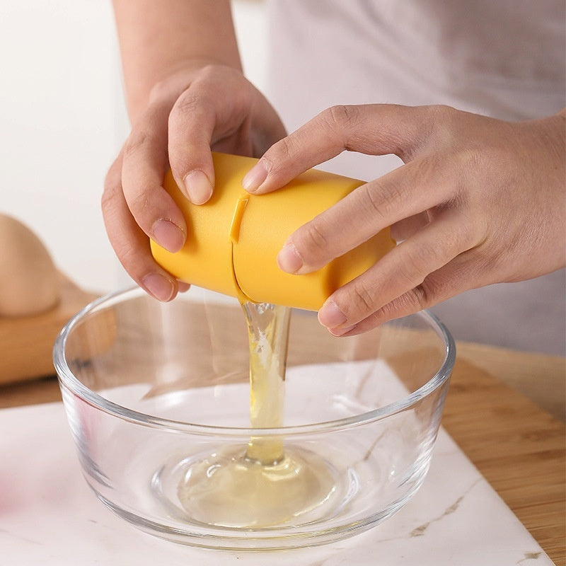 Hands using a mess-free egg cracker tool to crack an egg into a glass bowl.